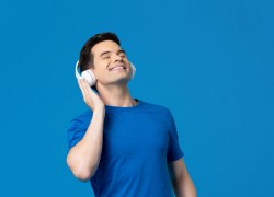 Relaxing young man listening to music from headphones with eyes closed